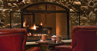 Mugs of Cocoa sitting in front of a fireplace