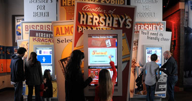a mother and daughter interacting with an touchscreen kiosk at The Hershey Story museum