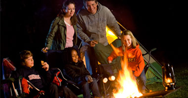 a family at a campfire in Hersheypark Camping resort