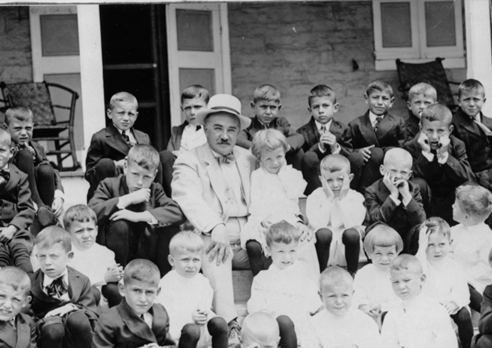 Milton Hershey sitting with kids from the Milton Hershey School