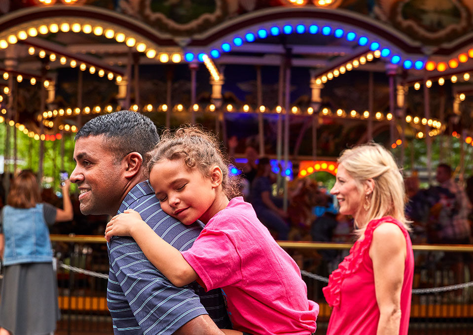 a family walking in front of the Carousel