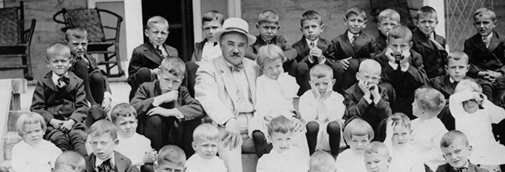 Milton Hershey and boys on the steps of Milton Hershey School