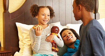 A family talking on the Hershey Hotel bed