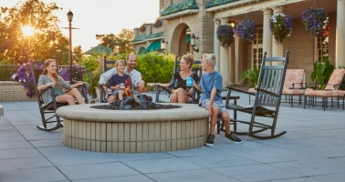 family enjoying fire pit outside of resort