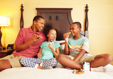 Family enjoying cookies inside of a Hershey Lodge bedroom.