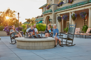 Family gathered around the outdoor lit firepit at The Hotel Hershey, enjoying s'mores and hot chocolate.