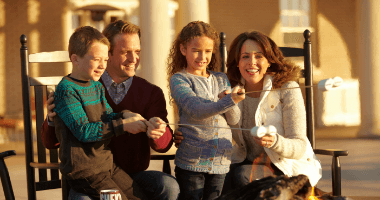Family enjoying time together and roasting marshmallows outside of The Hotel Hershey