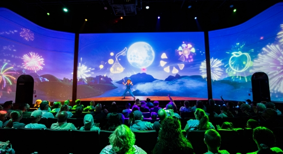 theatre full of people watching an actor perform on a stage inside of the Hershey's Chocolate World.