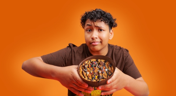 Boy holding up his customized large reese's cup that he created at Chocolate World.
