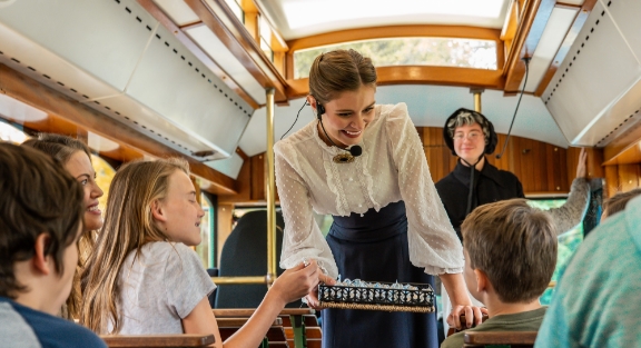 Trolley attendant handing out chocolate to children on the trolley ride tour.