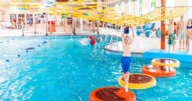 a boy walking across Reese's Water Walk in the Water Works pool at the Hershey Lodge