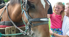 Father and daughter petting horse