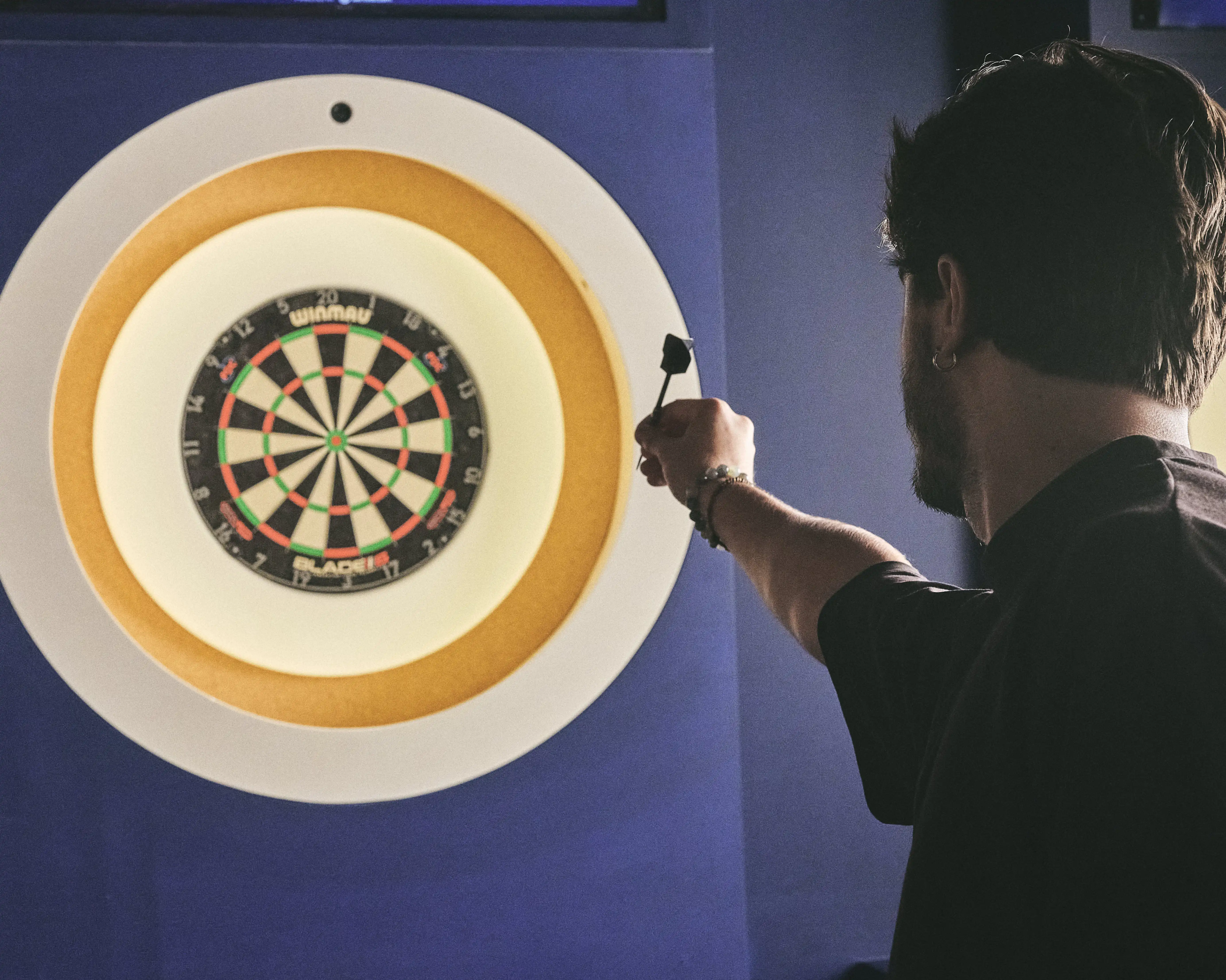 A photo of a man playing darts